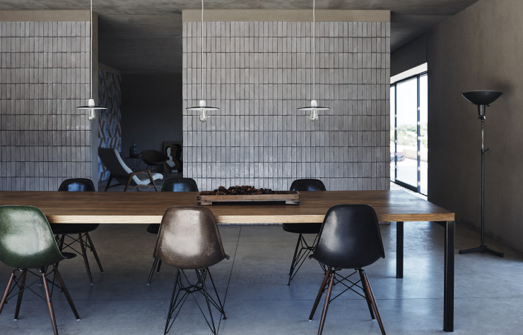 La salle à manger est simple d’usage mais somptueuse. Son mur blanc est pavé de céramique de Caltagirone, dont l’irrégularité artisanale et la brillance suggèrent bien la fraîcheur. Dans cette villa, personne ne voulait voir défiler de collection d’icônes du design. Quelques « Plastic Side Chairs DSW » et « DSR » des Eames (Vitra) ont néanmoins trouvé leur place.