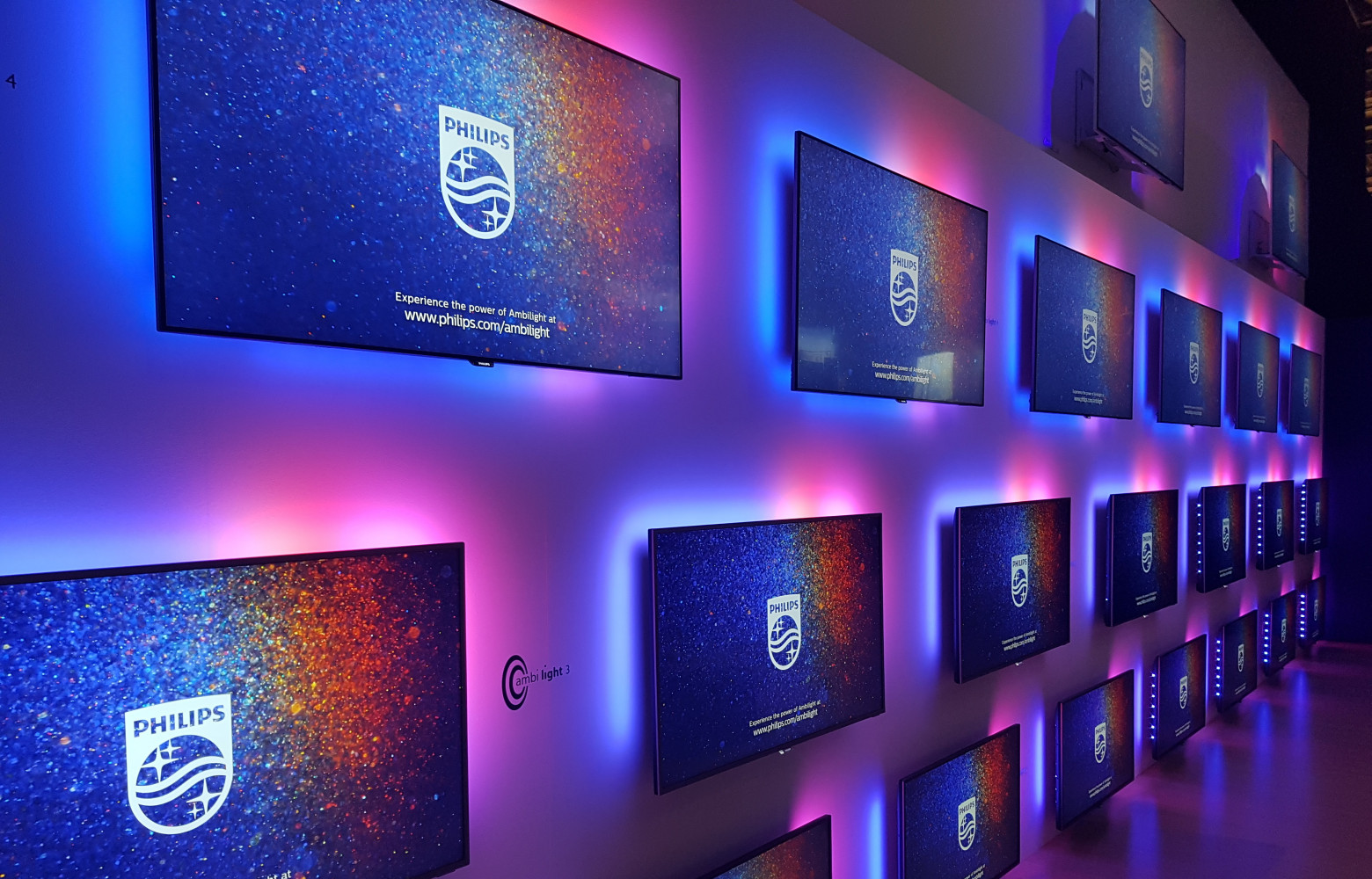 Téléviseurs Philips équipés de la technologie Ambilight qui projette au mur des halos colorés améliorant la lisibilité...