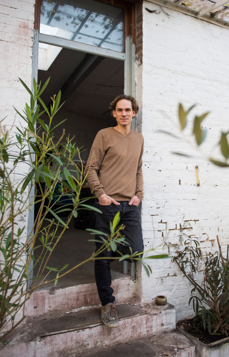 L’artisan-artiste à l’entrée de l’orangerie attenante à son bureau-atelier. L’omniprésence des plantes est nécessaire à son inspiration et à sa sérénité.
