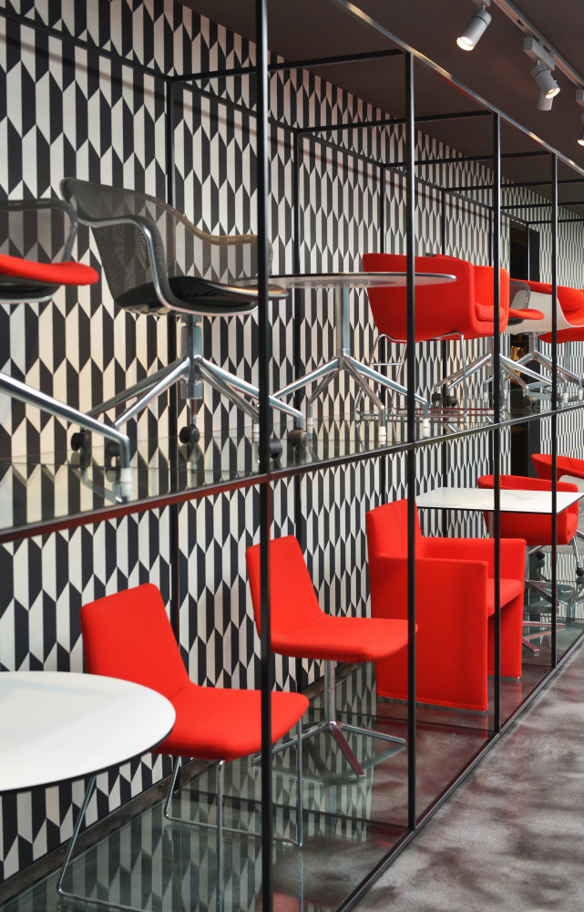 Dans le showroom, l'offre de tables et d'assises dédiée aux bureaux s'expose aux visiteurs, sur fond de...