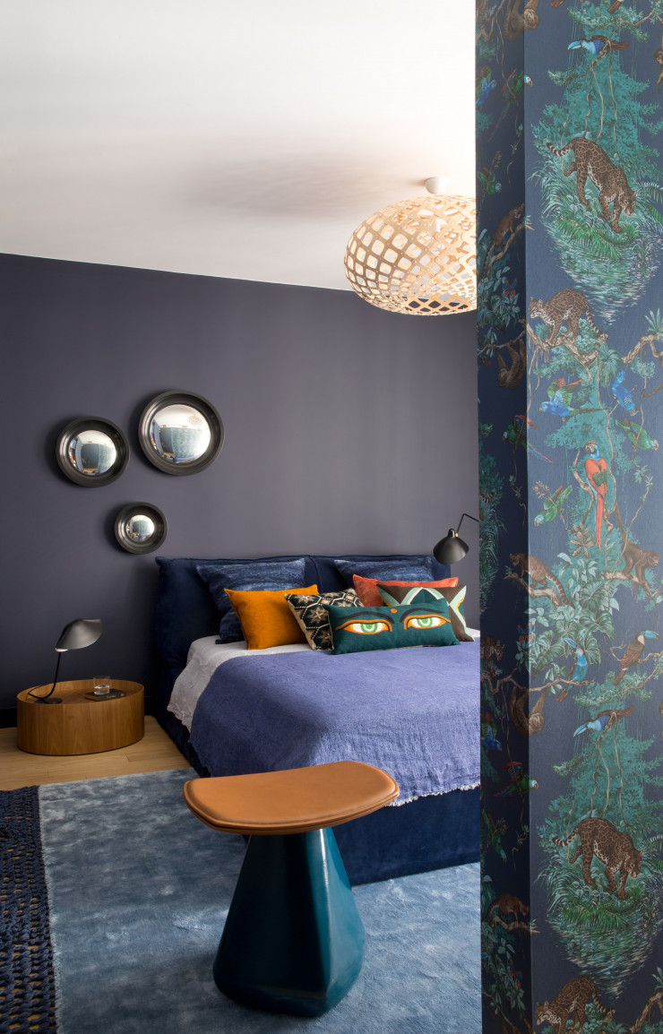 Dans la chambre parentale, le lit « Slim » signé Paola Navone (Baxter) jouxte un chevet de Pierro Lissoni (Porro). Miroirs de sorcière (Ochre) et tapis (Baxter). Draps, coussins et couverture (Maison de Vacances). Coussins brodés (Lindell & Co). Tabouret « Dam » créé par Christophe Delcourt (Collection Particulière) et lampe de table (Les Luminaires de Serge Mouille).