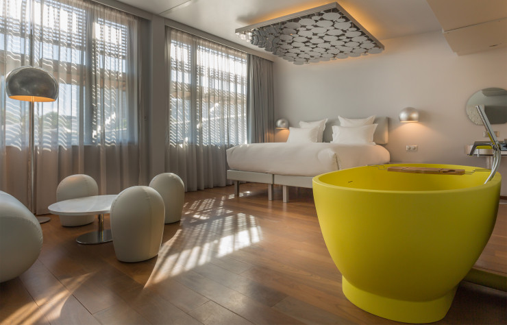 Dans la suite Designer Silver, une baignoire jaune canari contraste avec les tons grèges de l’ensemble. Et un patchwork de miroirs au-dessus du lit reflète les remous de la Seine…