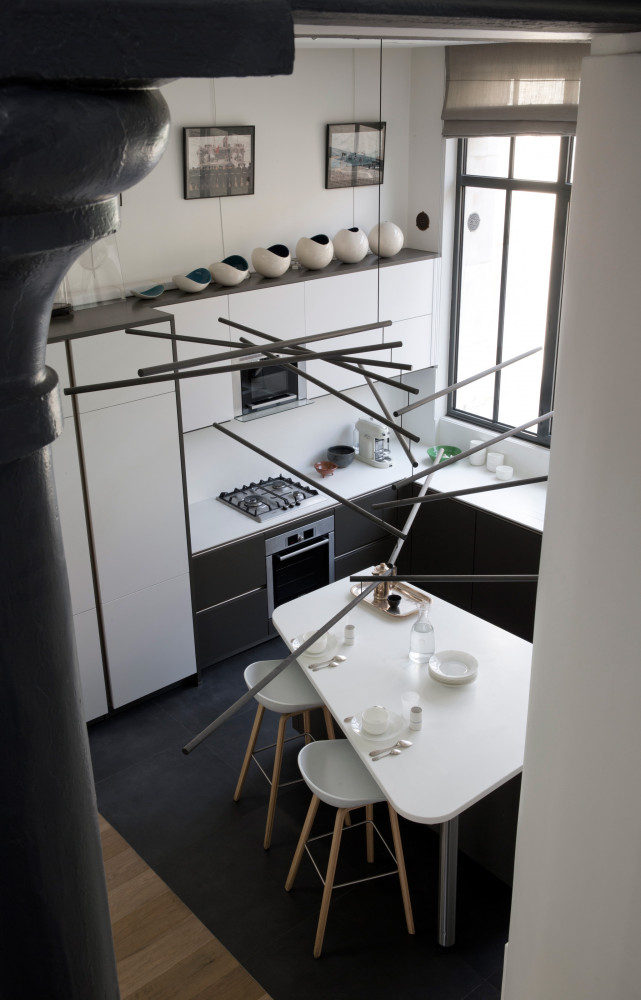 Depuis l’escalier, vue aérienne sur la cuisine. Vaisselle blanche par De Intuïtiefabriek (Château de la Resle).