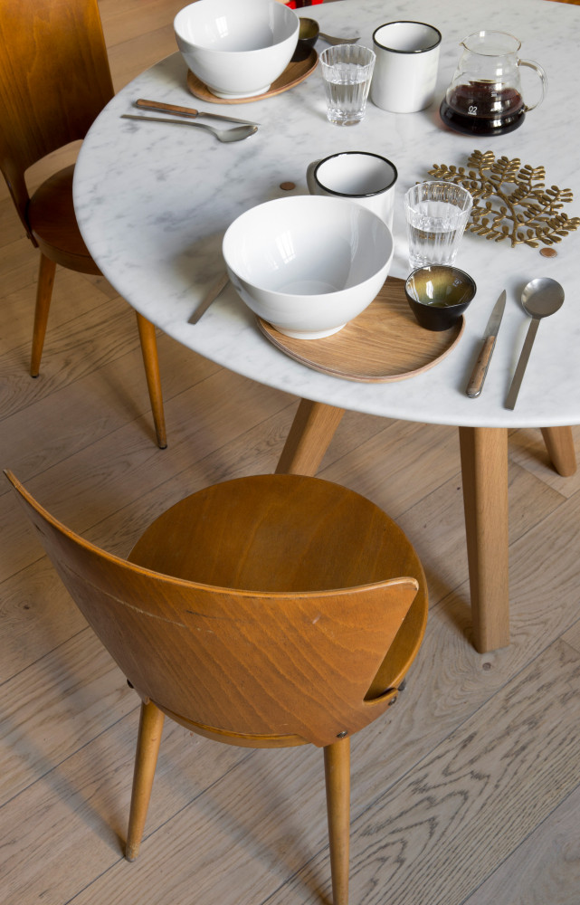 Autour de chaises en bois vintage, une table Arthur de la collection « Remix », dessinée par...