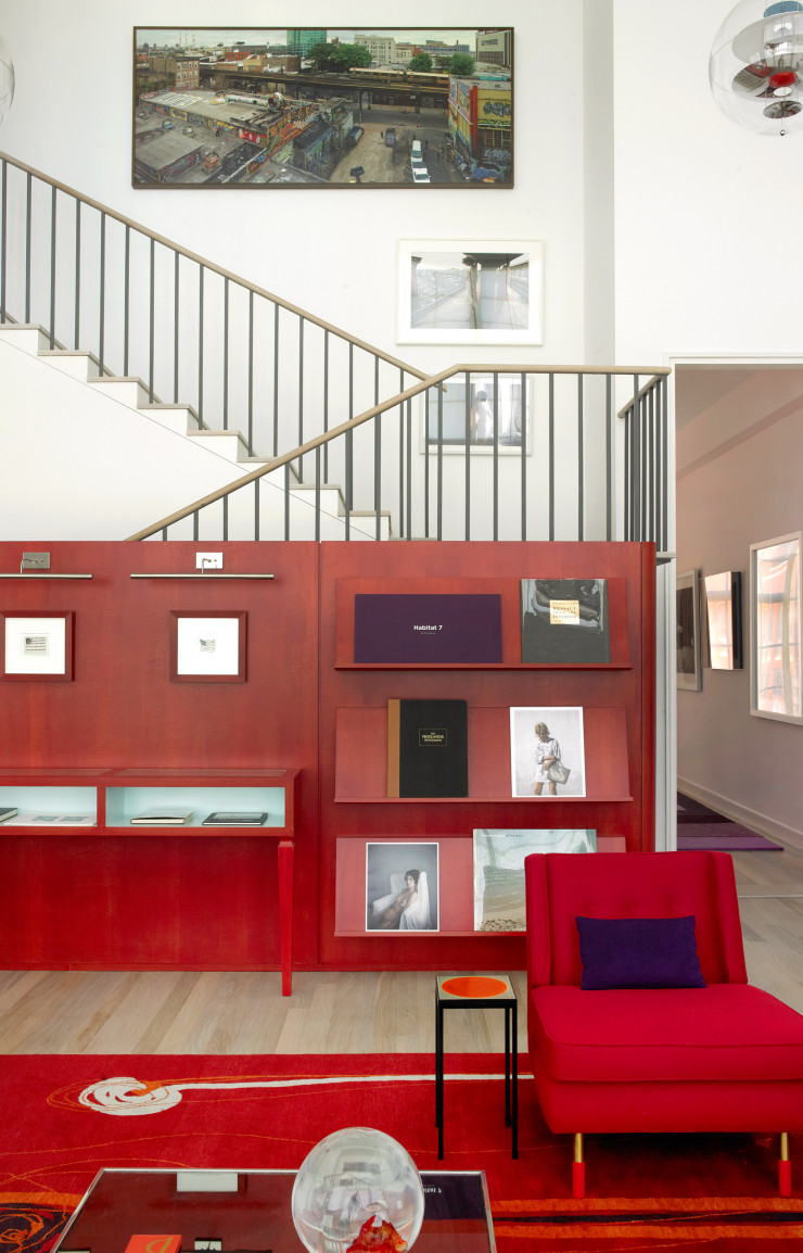 Dans ce même duplex, le salon, avec ses suspensions « VP Globe », de Verner Panton, est habillé de mobilier rouge. Fauteuil Dunbar vintage en flanelle. Table d’appoint en verre de Joe D’Urso. Tapis sur mesure de Doug et Gene Meyer.