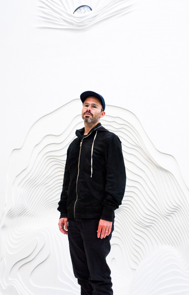 Daniel Arsham devant l’une de ses sculptures : comme si elle entamait la matière même des murs.