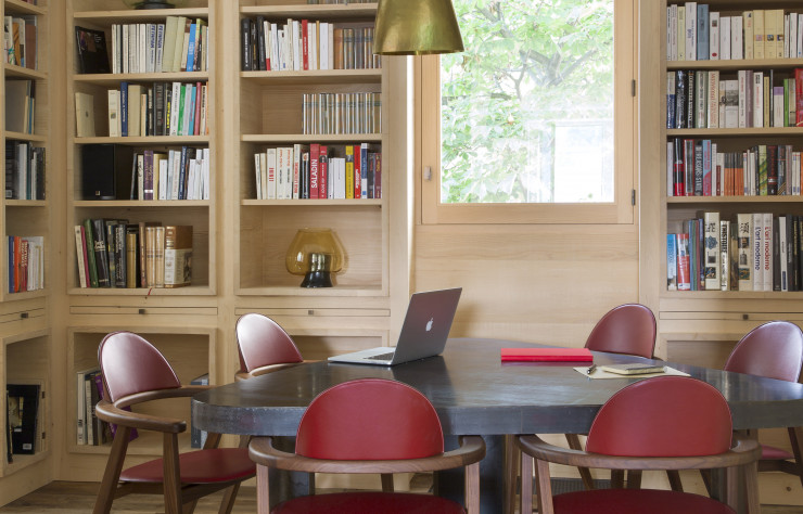 Les murs et les étagères en pin massif de cette bibliothèque accueillent des lampes dessinées spécialement par Pierre Yovanovitch.