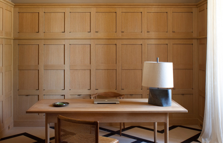 La table de Hans Wegner (circa 1950) rappelle le chêne sablé des boiseries murales de ce bureau.
