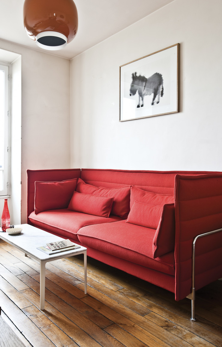 À la maison, le sofa Alcove des Bouroullec (Vitra) sous la suspension Chouchin qu’elle a conçue pour Foscarini.