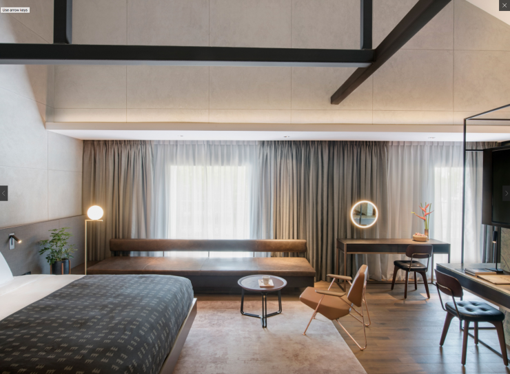 Une chambre du Warehouse avec son fauteuil Polygon de Numen/Foruse (Prostoria) et sa lampe sur pied de Michael Anastassiades (Flos).
