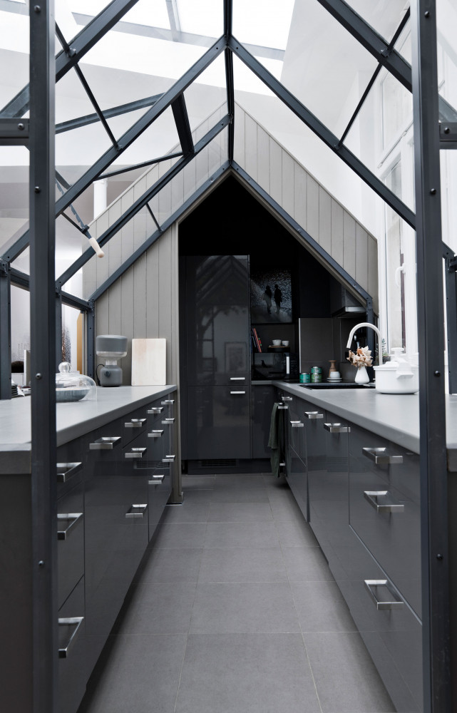 La cuisine s’intègre dans le séjour, subtilement circonscrite par une serre (Garden Factory) qui permet à la...