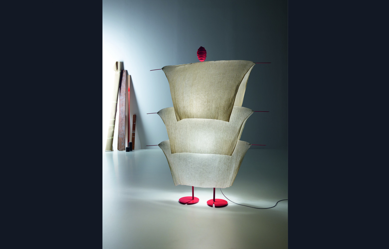 Cette sculpture d'Ingo Maurer évoque un personnage emmitouflé dans un imperméable nippon traditionnel tressé en paille. En...