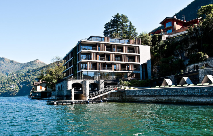 L’architecture d’Il Sereno, dessinée par Patricia Urquiola, se fond dans la nature, laquelle entre à l’intérieur du bâtiment à travers des baies vitrées rythmées de claustras de bois modulables.