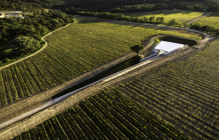 Le pavillon de photographie se fond dans la terre du domaine. Un chemin en pente douce permet d’y accéder et de faire entrer la lumière dans l’espace d’exposition.