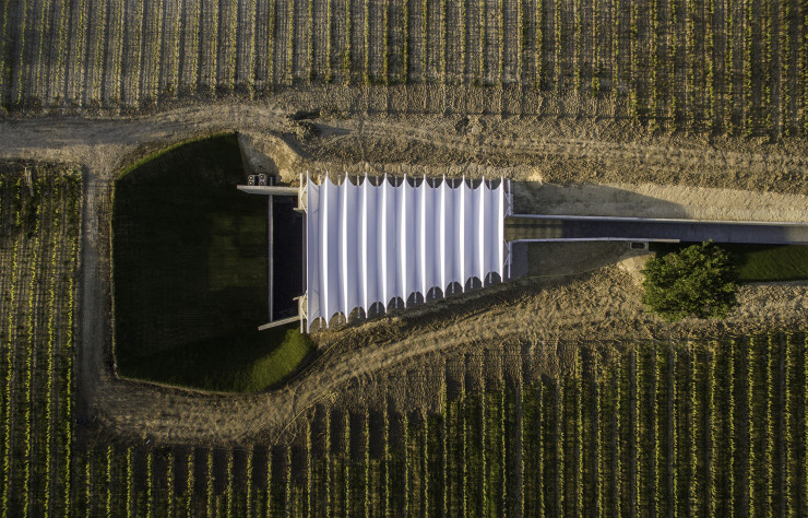 Le pavillon vu du ciel, avec son toit tendu de toile blanche. Son rythme visuel reprend celui des rangées de vignes.