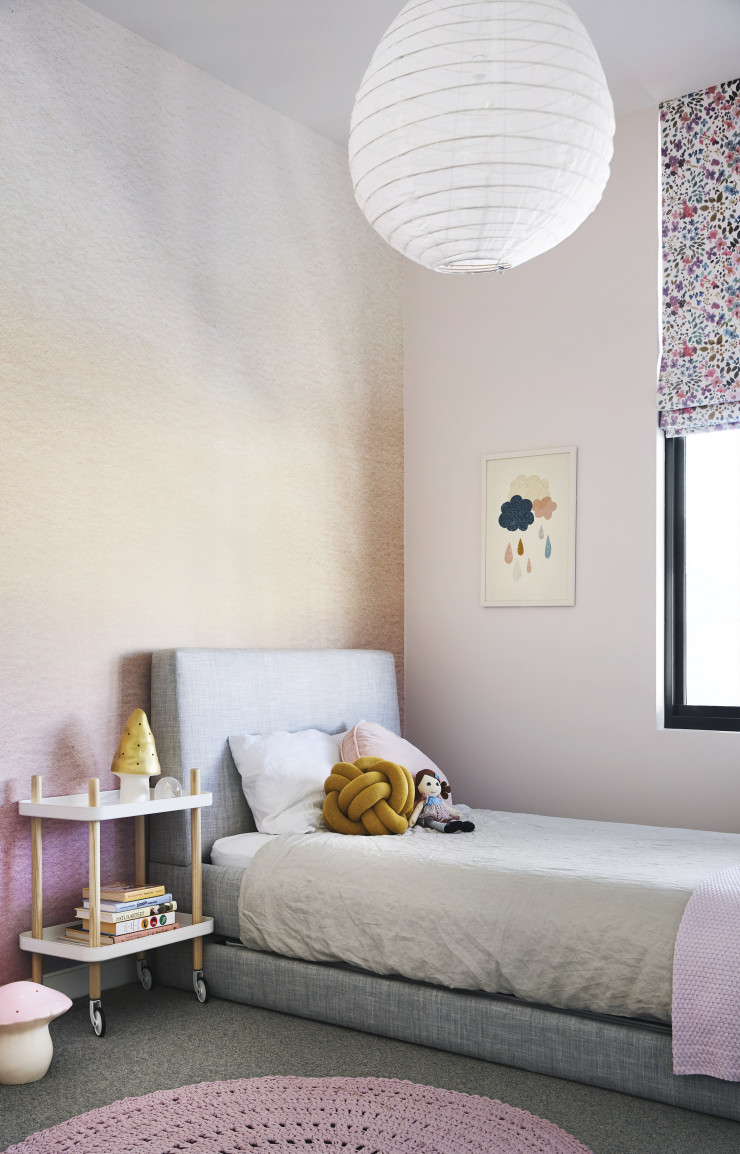 Des teintes douces, roses et pêche, ont été choisies pour cette chambre d’enfant. Lit de Lilly & Lolly, suspension Paris Au Mois d’Août, coussin Knot (Unemi).
