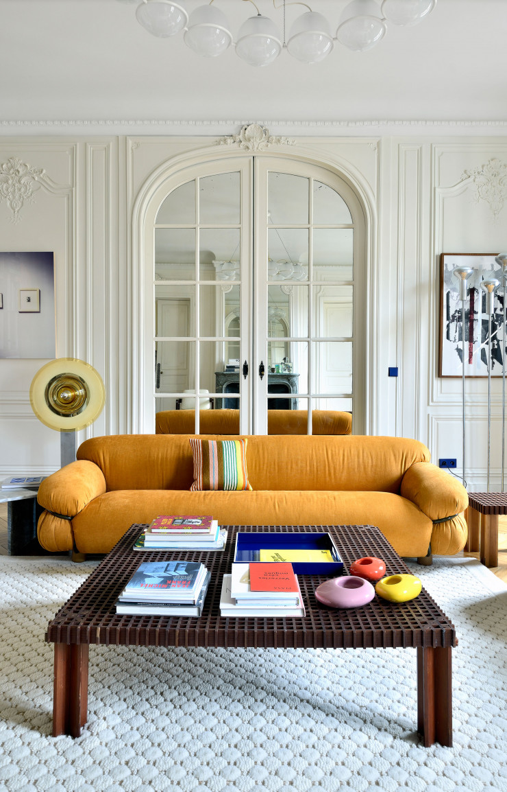 Le canapé Sesann de Gianfranco Frattini (Tacchini) impose sa présence grâce à sa belle couleur safran. Tables basses de Gianfranco Frattini. À droite; derrière la lampe de Gino Sarfatti; tableau de Meredyth Sparks.