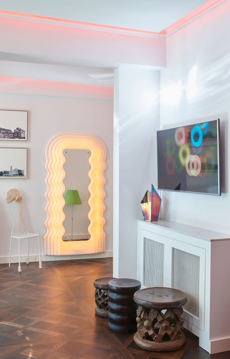 Dans l’entrée, trois tabourets africains. Sur le radiateur, vase d’Andrea Branzi. Au-dessus, photo extraite de la vidéo Atomic City de Frank Perrin. Au fond, miroir Ultrafragola d’Ettore Sottsass (Centro Studi Poltronova). À gauche, chaise Picnic de Junya Ishigami (Living Divani). Au mur, photos Ruins Post Capitalism de Frank Perrin.