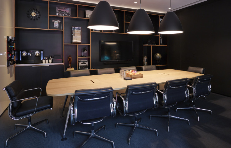 Plus studieuse, cette salle de réunion mise sur le noir, grâce notamment aux « Aluminium Chairs » de Charles et Ray Eames.