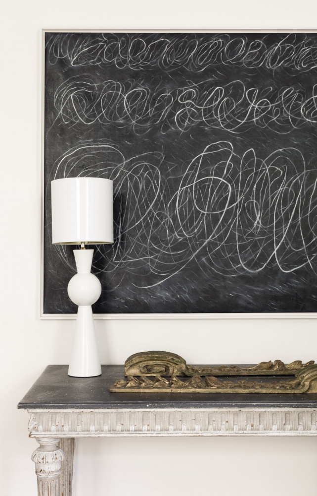 Un tableau de Cy Twombly surplombe une table en bois peint du XVIIIe siècle, un élément architectural...