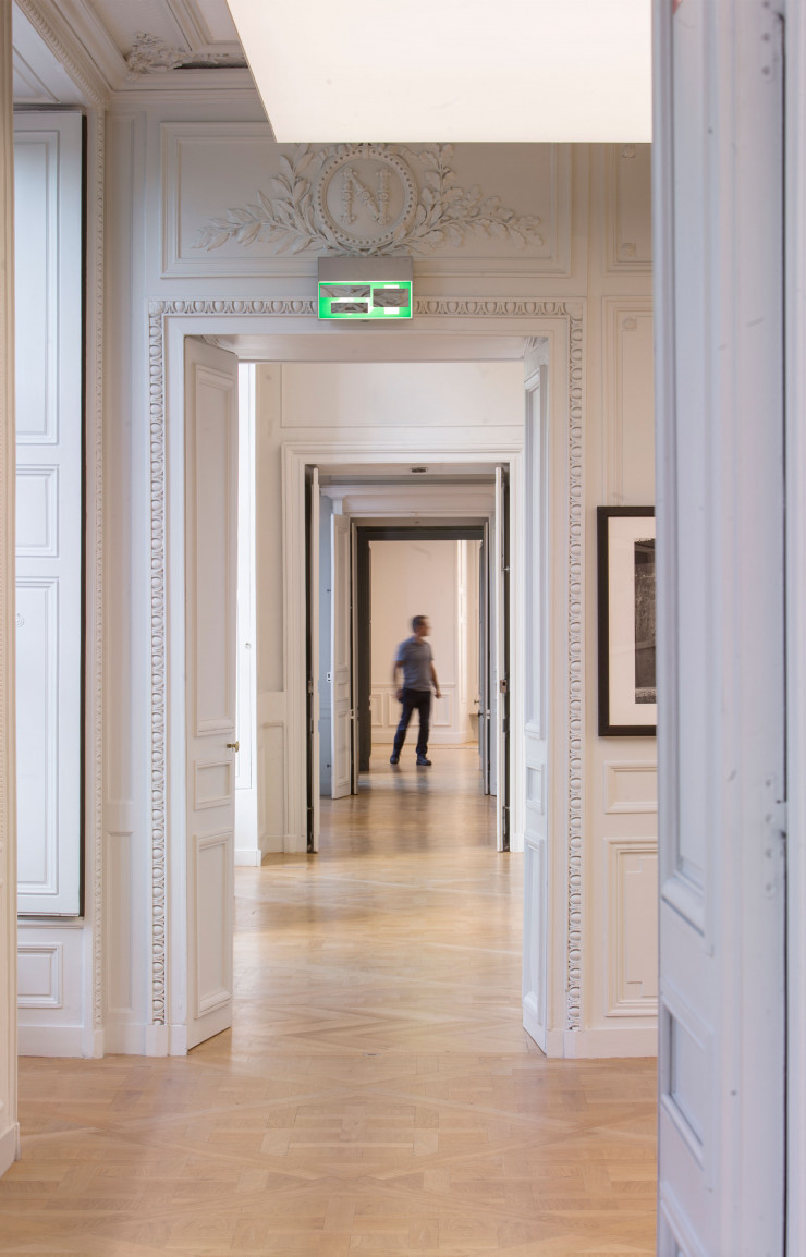 Enfilade néoclassique des salons aux parquets clairs et aux murs blancs décorés de frises.