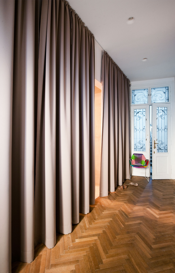 Dans l’entrée, un grand rideau sépare le hall de la salle de bains et abrite également le dressing. Contre la porte, chaise Tropicalia, design Patricia Urquiola (Moroso).