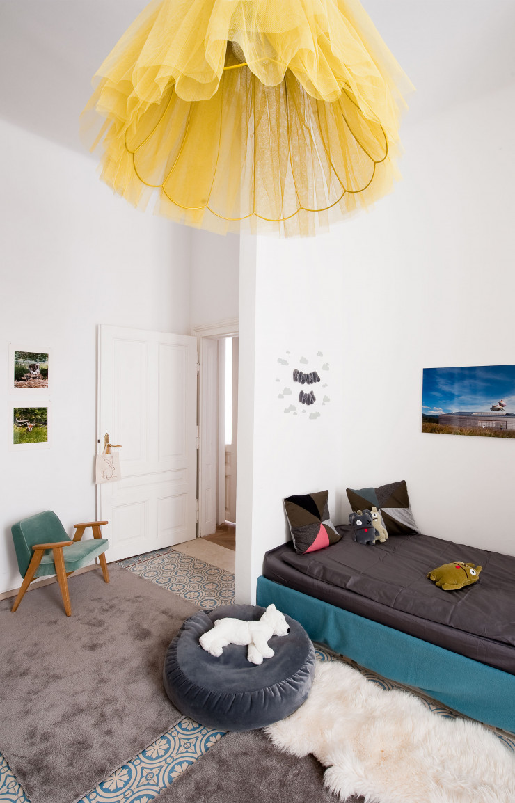 Dans la chambre des enfants, au-dessus du divan fabriqué sur mesure, photo de la série « Heim-lich, still und leise » (Autriche, 2011) par la propriétaire des lieux. À gauche, au-dessus du fauteuil 366 Concept Junior Velvet, de Józef Chierowski (366 Concept), photos de Bela Borsodi. Tapis Silky Seal (Object Carpet). Au premier plan, la suspension Corolle.