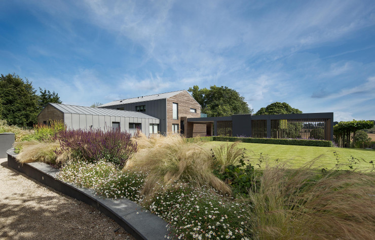 Le zinc de la ferme résonne avec le fibrociment de l’extension.