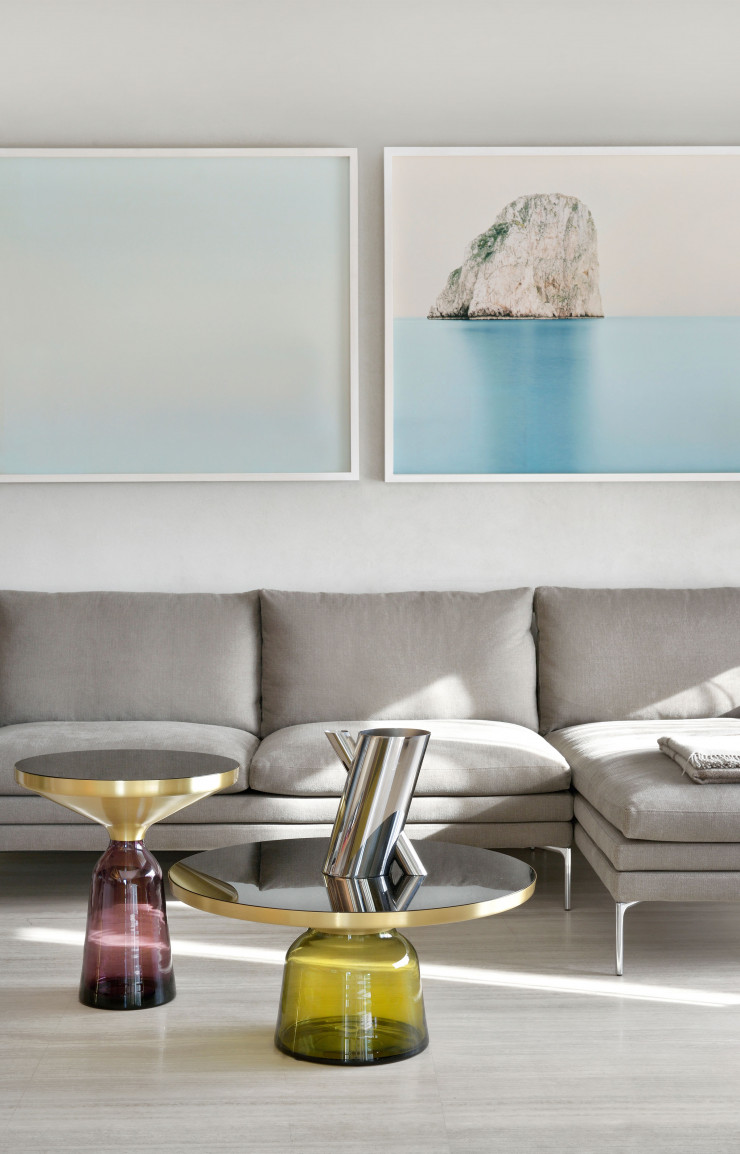 À l’intérieur de l’appartement imaginé par le studio 8&A  des photos d’auteur racontent l’Italie à travers des paysages, comme ici, dans le séjour, deux oeuvres de Francesco Iodice. Canapé William, de Damian Williamson (Zanotta), tables Bell, de Sebastian Herkner (ClassiCon), et vase Tronco, de Mario Botta (Alessi).