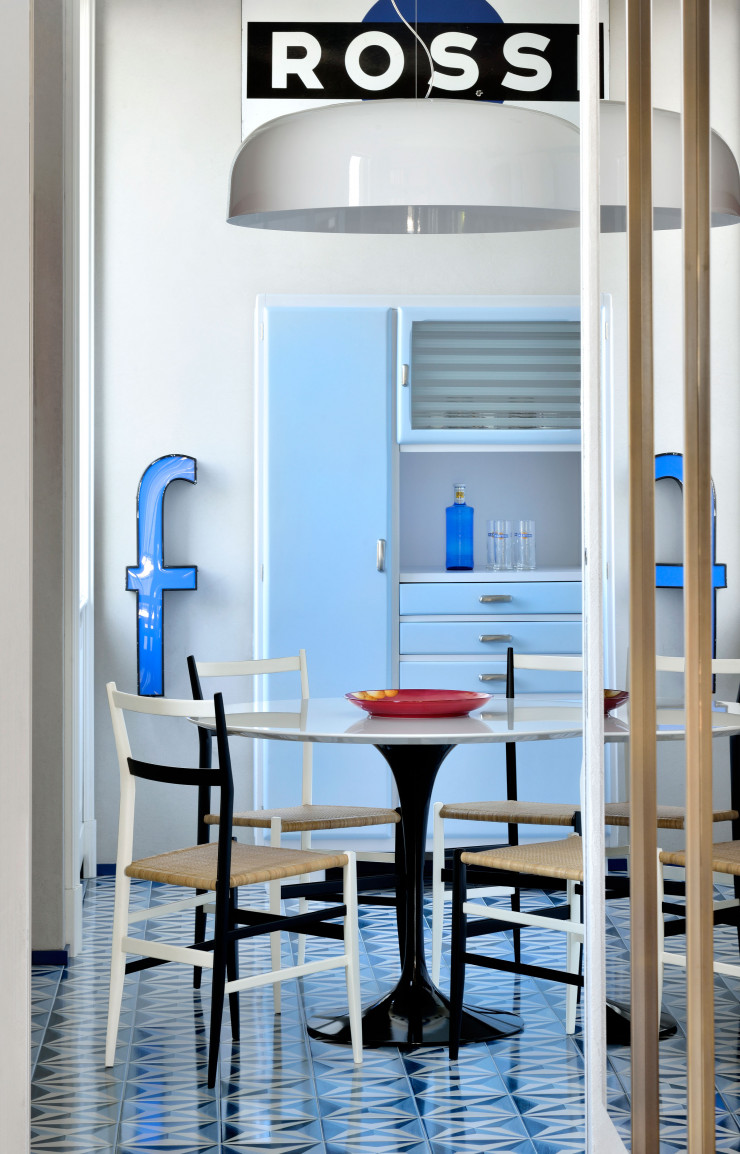 Dans la cuisine se déclinent des tons de bleu, couleur chère au maître des lieux. Carrelage au sol dessiné par Gio Ponti (La Riggiola). Table Tulip, d’Eero Saarinen (Knoll), chaises Superleggera, de Gio Ponti (Cassina), et suspension Canopy, de Francesco Rota (Oluce). Au fond, un buffet vintage restauré.