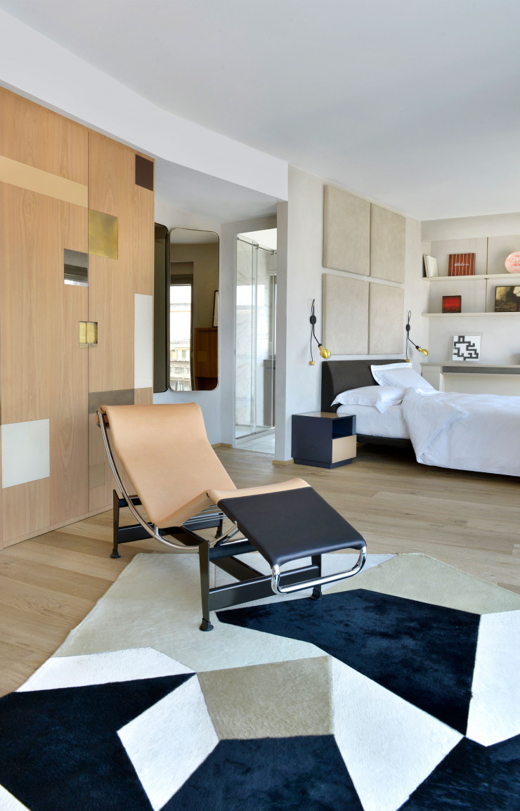 Vaste et lumineuse, la partie nuit occupe l’étage supérieur. Boiseries en noyer sur mesure de 8&A, lit Talamo, de Damian Williamson (Zanotta), chaise longue LC4, de Le Corbusier, Pierre Jeanneret et Charlotte Perriand (Cassina), tapis D.754.1, de Gio Ponti (Molteni&C), et appliques Wall Lamp, de Maurizio Navone (RestartMilano).