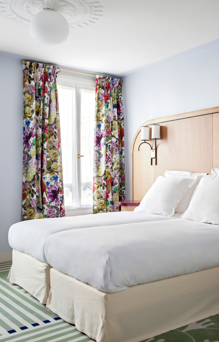 Dans les chambres, les lignes graphiques de la moquette répondent aux motifs des rideaux.