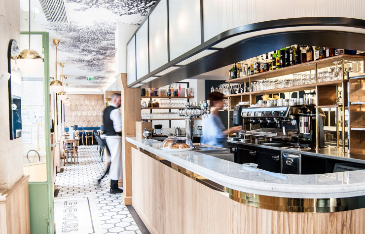 Au Nemours (Ier) : le bar central en marbre, très Art déco, répond au dallage graphique du sol. Une gravure végétale du XVIIIe a envahi murs et plafond.