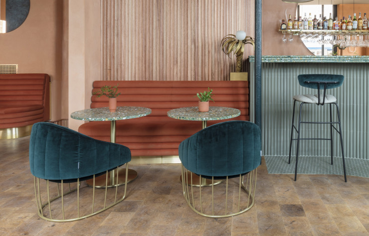 Signés Note Design Studio, les fauteuils « Tonella », aux dossiers capitonnés placés dans l’alignement de la structure en laiton.