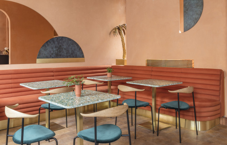 Parées d’un tissu Kvadrat, les chaises « CH88 » d’ Hans Wegner contrastent avec la tonalité pêche des banquettes sur-mesure.