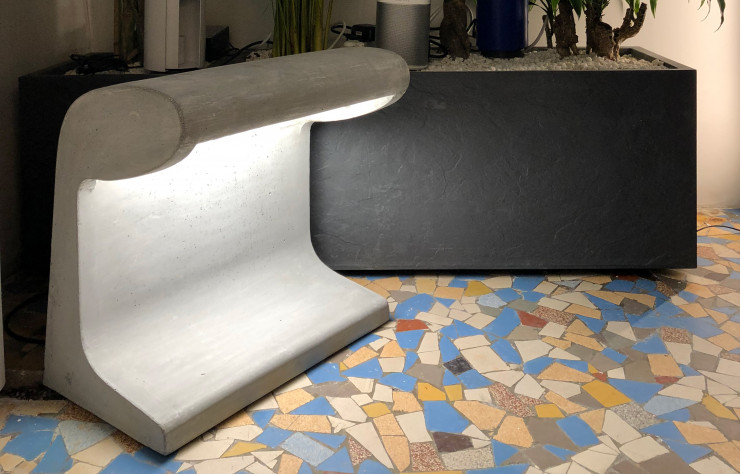 La lampe Borne Béton de Le Corbusier est exposée au fond du showroom.