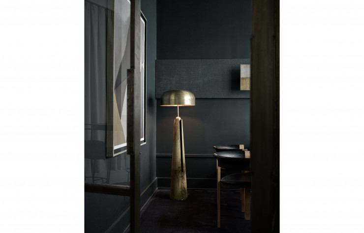 Au fond du corridor bleu nuit, un exemplaire de la série de luminaires « Metronome ». Le cuir très doux recouvrant le pied du lampadaire et le métal patiné de l’abat-jour sont autant d’eff ets qui tempèrent l’aspect massif de l’ensemble.
