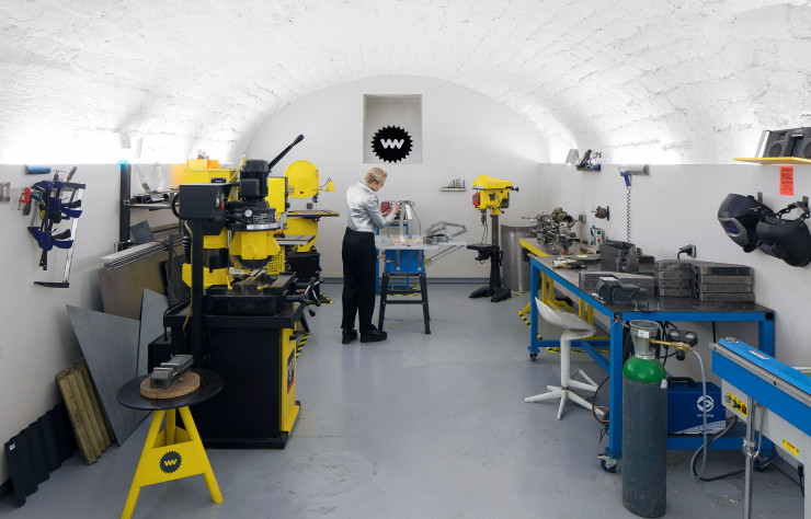 Dans la salle des machines, repeintes en jaune par ses soins, la designer, entre scie à ruban et plieuse, est dans son élément. Certaines de ses créations sont intégralement réalisées sur place.