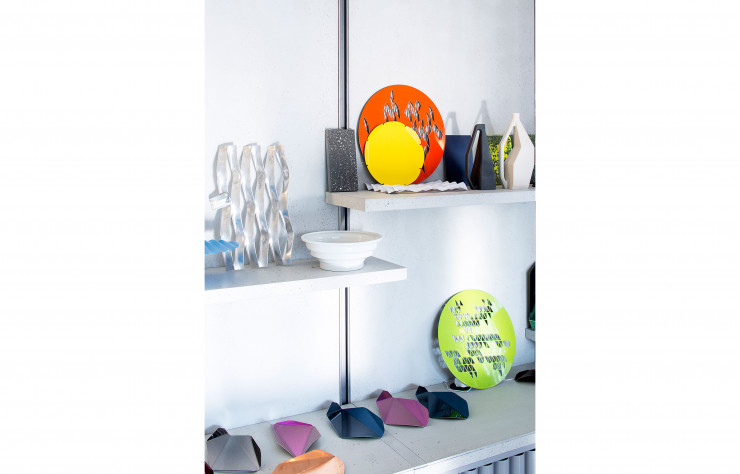 Sur les étagères du bureau, les objets sont colorés et graphiques, des couvercles en émail des boîtes de rangement en marbre aux carafes, en passant par les petits plateaux métalliques pliés (VW Factory).
