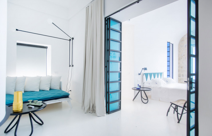 L’une des plus belles chambres du Miramare Sea Resort.. Les têtes de lit sont habillées de tissus Livio de Simone. Tables basses Arch de Front (Gebrüder Thonet Vienna) et appliques Bolt (Tonone).