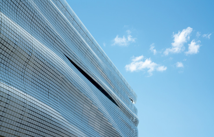 La géométrie des carreaux sérigraphiés répond aux ondulations de la façade.