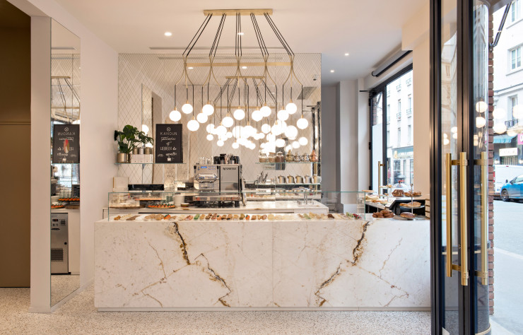 Derrière le comptoir, un grand miroir ouvragé et les cuisines.