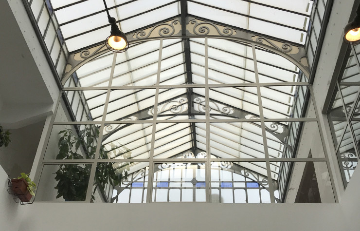 La verrière du bâtiment diffuse sa lumière zénithale à travers les deux étages du concept-store.