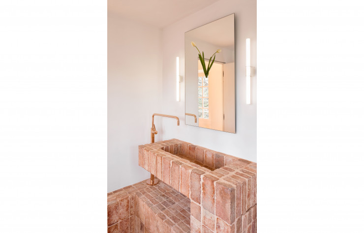 La matière brute des briques de terre contraste avec la ligne limpide de la verrerie, les tons cuivrés évoquant la chaleur provençale dans la chambre C.H.0.0.1., du Studio Quetzal, qui capte divinement la lumière naturelle.
