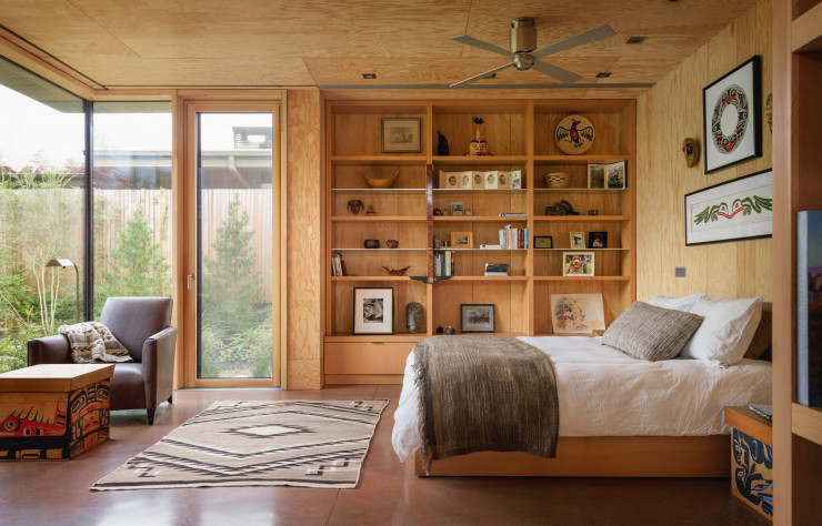 La chambre, habillée de panneaux de contreplaqué et sobrement meublée.