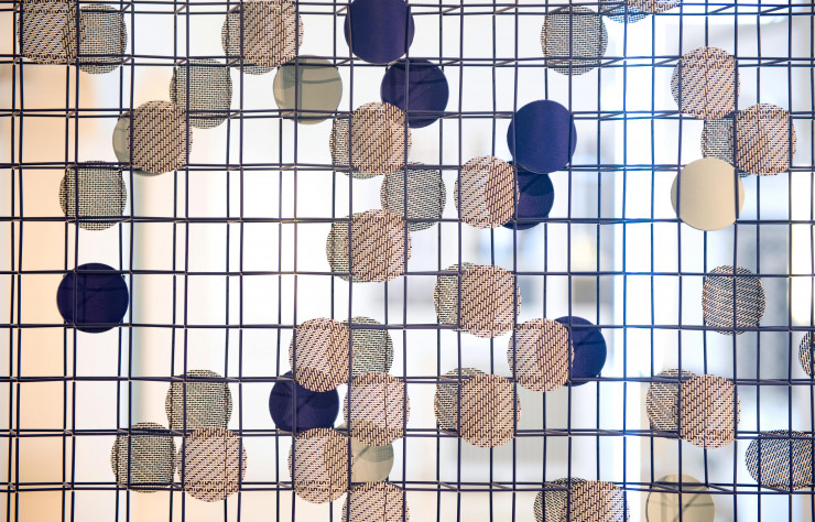 Grille en tubes de métal laqué, animée par des confettis de cuir et de tissu.