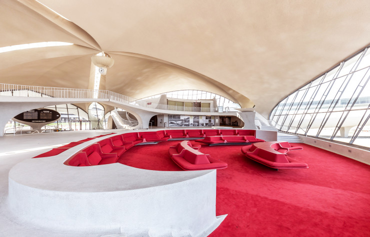 Un intérieur en ellipse conçu pour faciliter la circulation des voyageurs, la teinte flamboyante des moquettes et des assises du salon d’attente tranchant avec le blanc immaculé du plafond et des sols, les panneaux d’affichage des vols et jusqu’à l’horloge suspendue au centre… Ce décor intégralement imaginé par Eero Saarinen pour la TWA Flight Center à l’aube des années 60 sera restauré à l’identique pour s’intégrer dans le futur complexe hôtelier de l’aéroport JFK de New York.