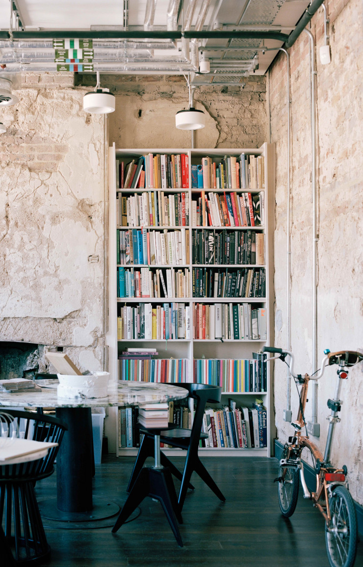 Le bureau de Tom Dixon, avec pierre et réseaux apparents et son vélo pliable Brompton.