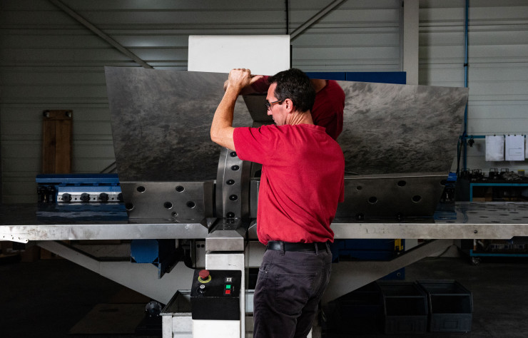 Une fois graissées à la main, les plaques d’acier Inox sont placées dans une poinçonneuse afin qu’on y découpe les pièces destinées aux luminaires ou aux grilles décoratives.