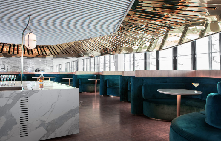 Dans le nouveau salon du hall L de l’aéroport Paris–CDG, le Balcon, signé Mathieu Lehanneur, est un bar circulaire qui s’enroule autour d’un cube de marbre central.